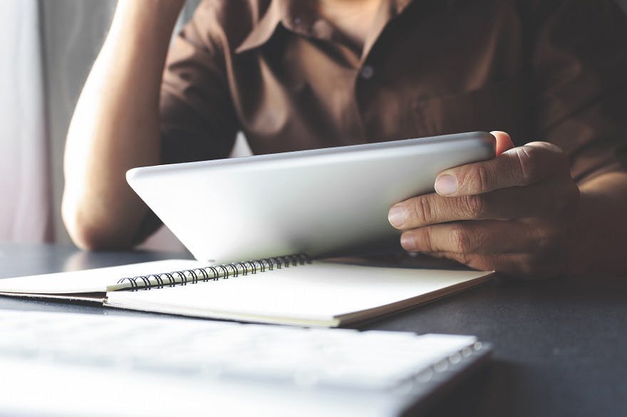 Image of a man looking at his tablet