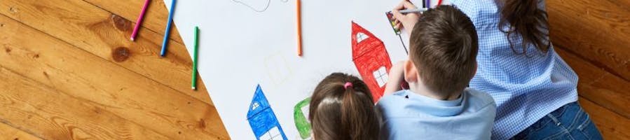 three children colouring a picture of houses