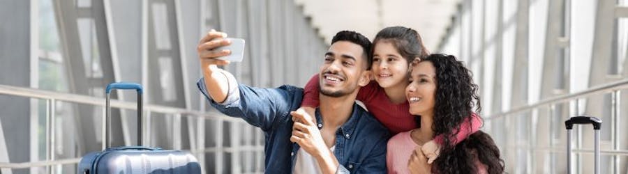 Photo of young family taking a selfie at the airport