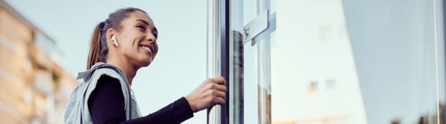 Photo of a young woman entering a gym