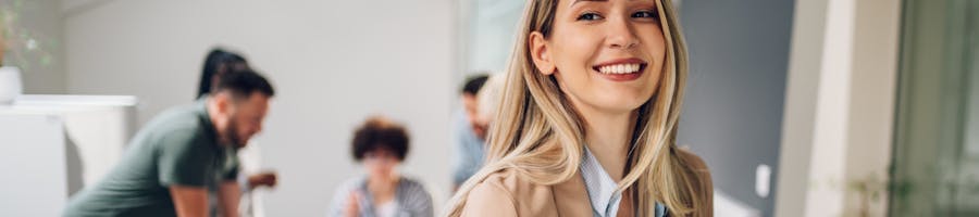 Woman with iPad smiling in tan blazer