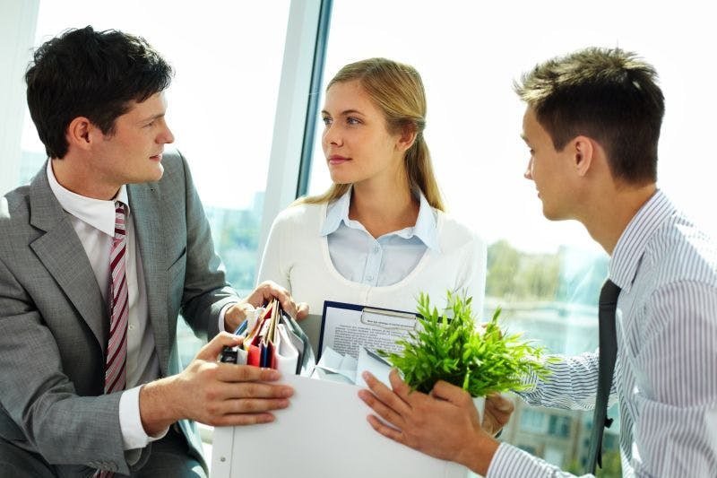 Office workers carrying a box of personal possessions