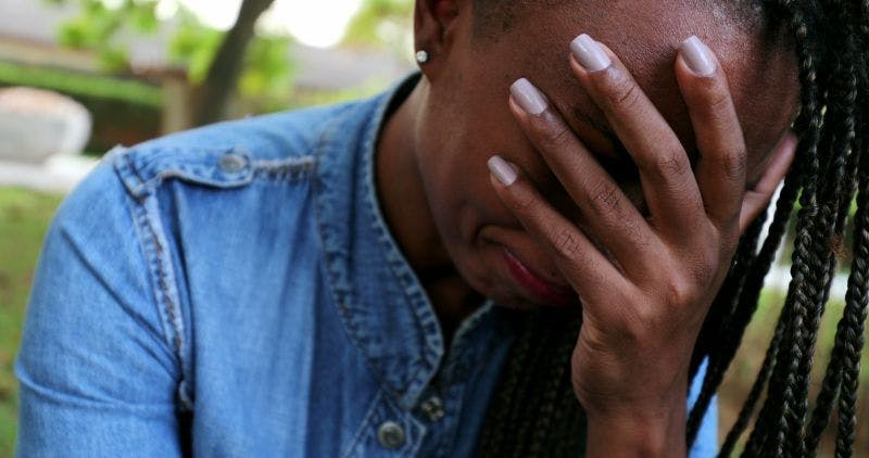 Sad woman with head in hands