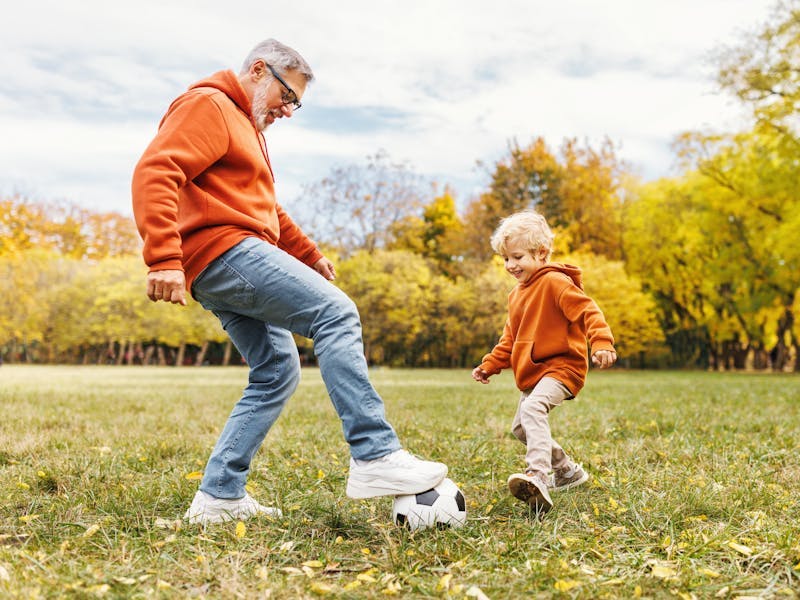 man and child playing football outside