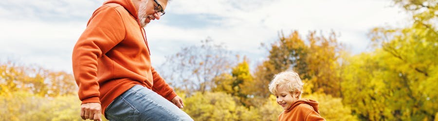 man and child playing football outside